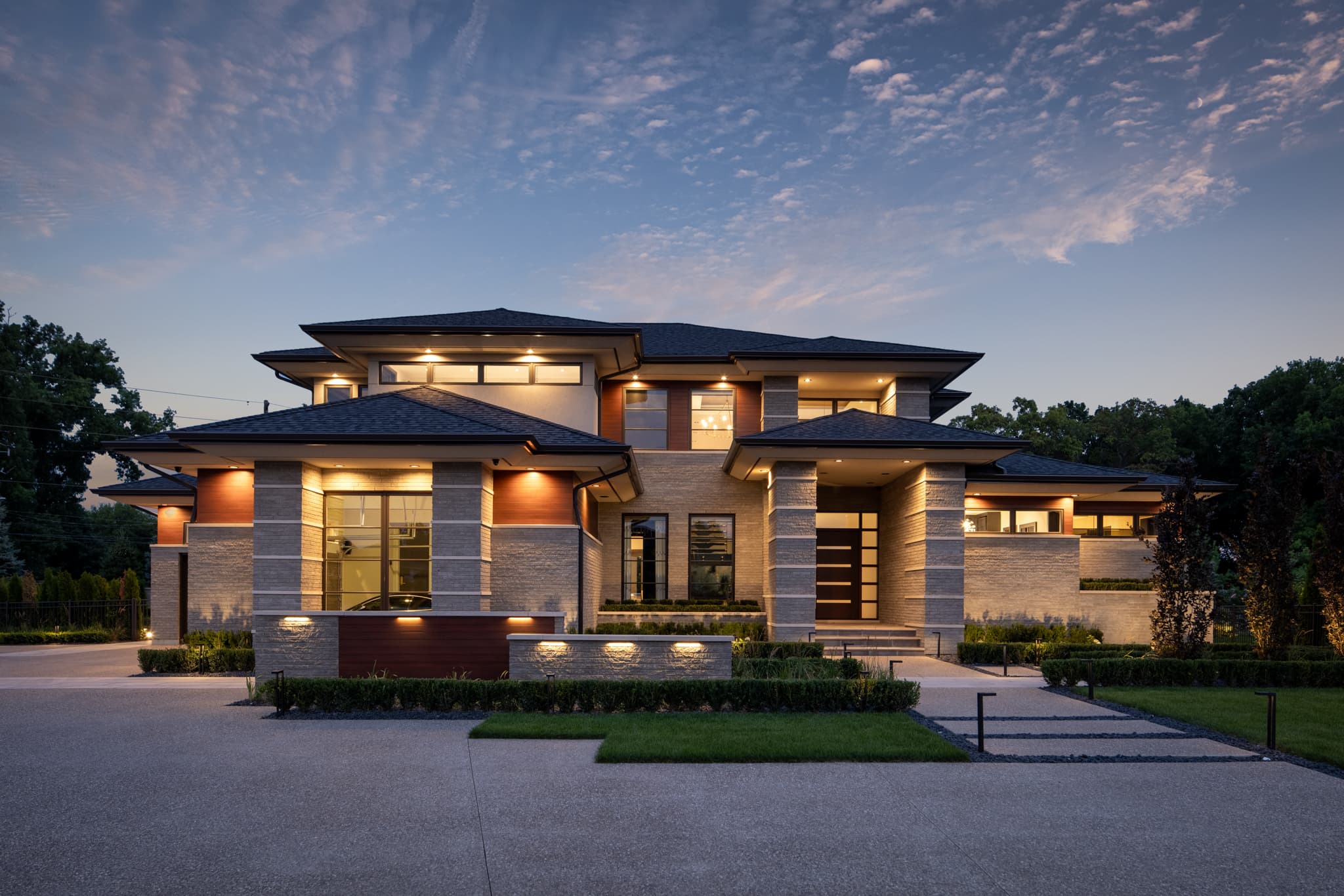 Modern luxury custom home exterior at twilight by Timberland Homes in Leamington, Ontario.