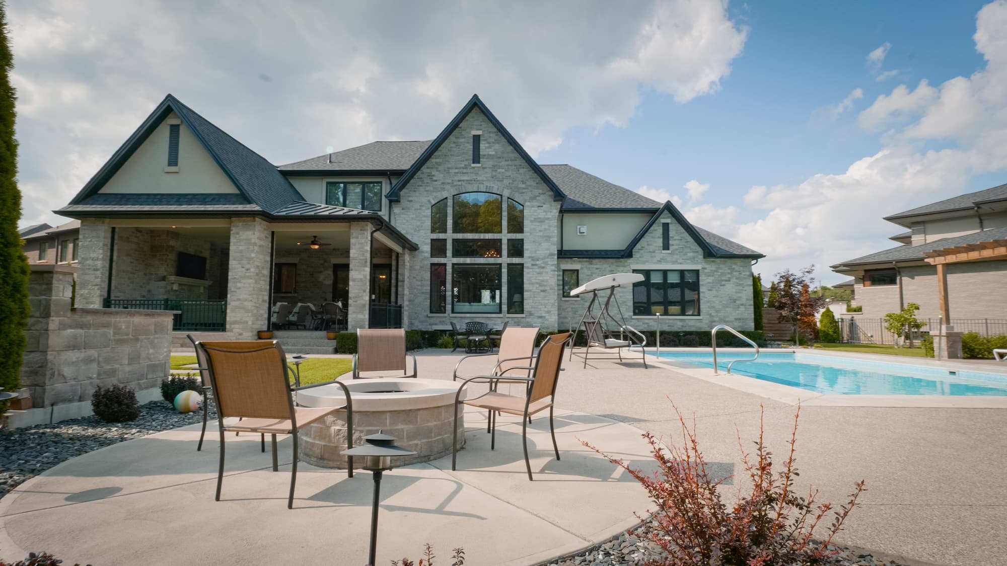 Custom home rear exterior with pool and outdoor living space by Timberland Homes in Kingsville, Ontario.